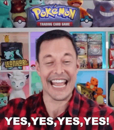Man Smiling in Front of Pokemon Trading Card Game Shelf