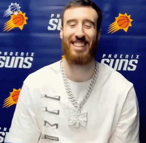 Man Smiling in Phoenix Suns Shirt Blue Wall
