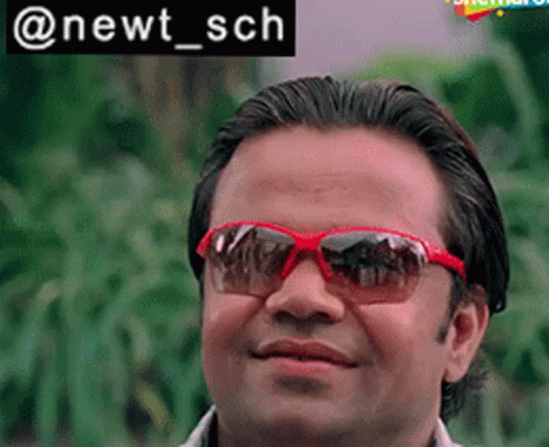 Man Smiling In Red Sunglasses With Plants GIF