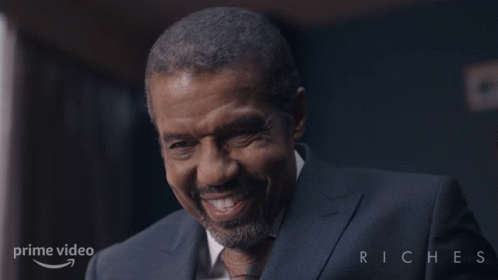 Man Smiling in Suit in Front of Prime Video Riches