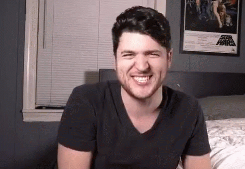 Man Smiling on Bed With Star Wars Poster