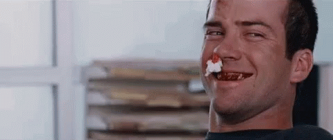 Man Smiling with Cake in Mouth
