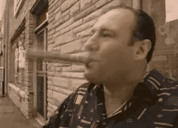 Man Smoking Cigar Outside Brick Building