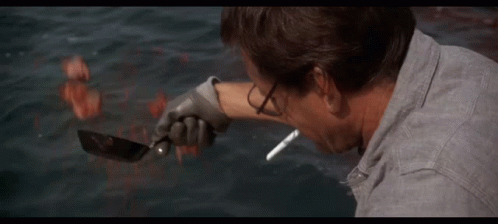 Man Smoking Cigarette in Front of Shark in Ocean