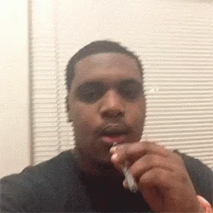 Man Smoking Cigarette Looking at Camera