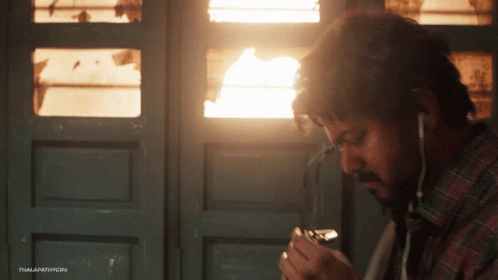 Man Smoking Cigarette With Ear Buds GIF