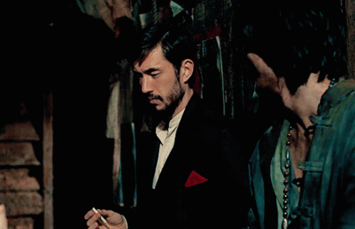 Man Smoking Cigarette With Red Pocket Square in Dark Room