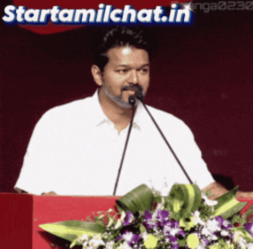 Man Speaking Into Microphone at Podium With Starttamilchat.in