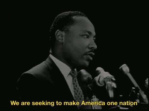 Man Speaking Into Microphone We Are Seeking To Make America One Nation