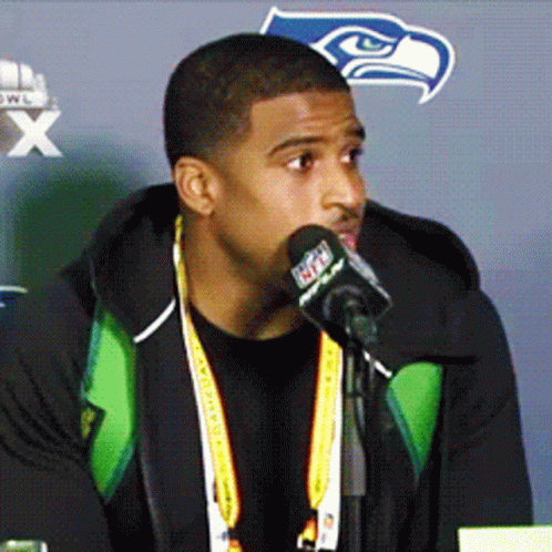 Man Speaking Into Microphone With Seahawks Logo