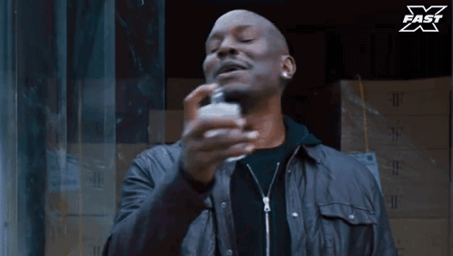 Man Spraying Perfume Bottle With X Fast Logo GIF