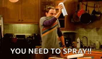 Man Spraying Something In Kitchen With Towel GIF