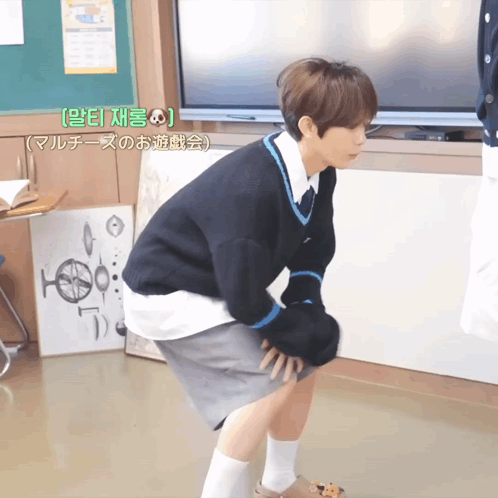 Man Squatting at Green Board With Chinese Writing