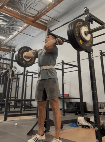 Man Squatting Barbell With Rogue
