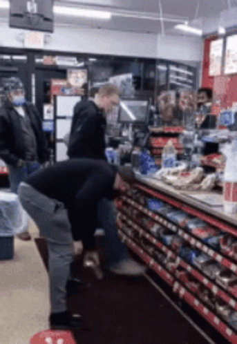 Man Squatting In Store With Exit Sign GIF