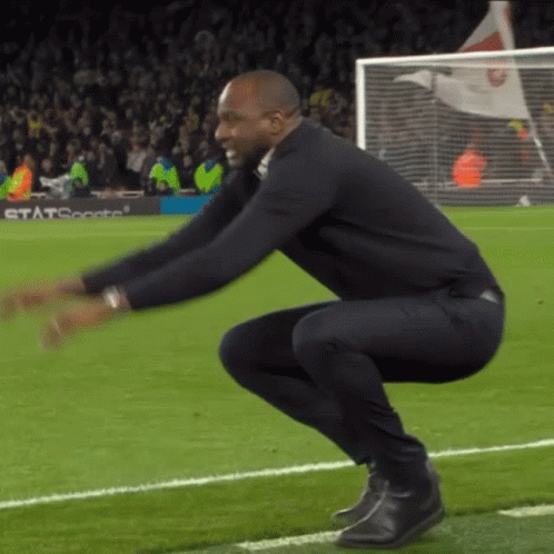 Man Squatting on Soccer Field