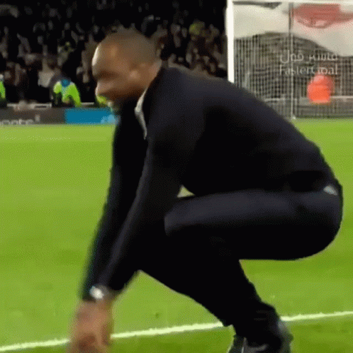 Man Squatting on Soccer Field