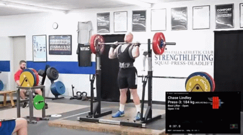 Man Squatting With Barbell In Front Of Strengthlifting Sign GIF