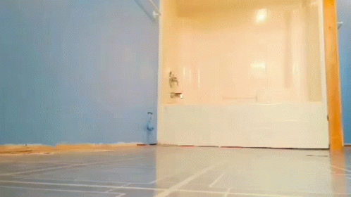 Man Standing in Bathroom Next to Bathtub