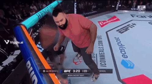Man Standing in Boxing Ring With Budweiser Ads