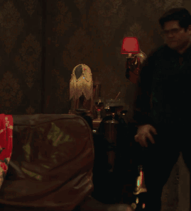 Man Standing In Dark Room With Red Lamp GIF