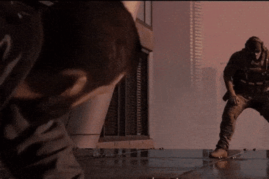 Man Standing In Front Of Building With Another Man Looking On GIF