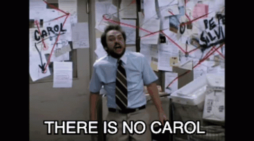 Man Standing in Front of Bulletin Board Saying Carol