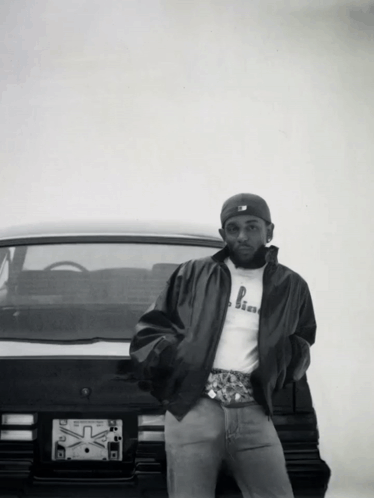 Man Standing in Front of Car with X License Plate
