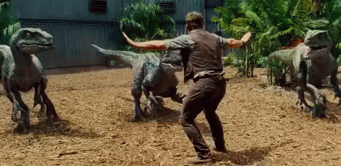 Man Standing In Front Of Dinosaurs GIF