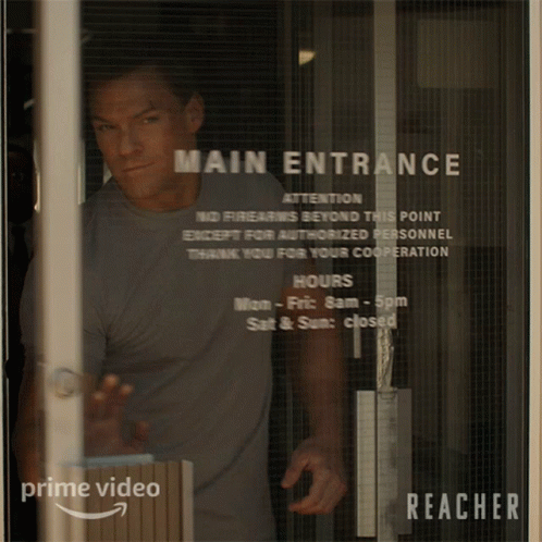 Man Standing in Front of Glass Door Saying Main Entrance