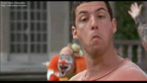 Man Standing in Front of Red Face Clown