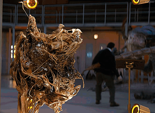 Man Standing in Front of Sculpture With Blurred Person Behind