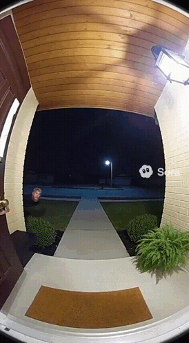 Man Standing in House Doorway at Night