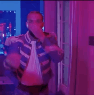 Man Standing in Purple Lit Room With Microphone