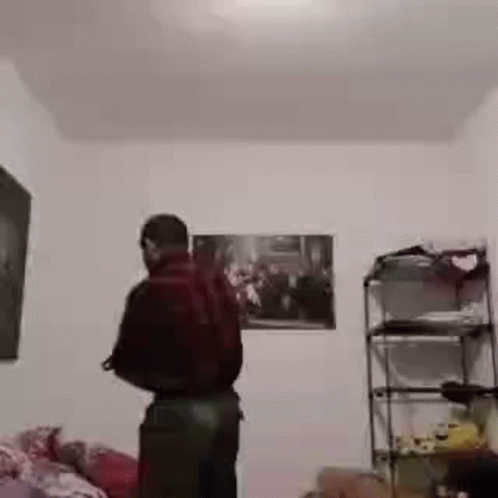 Man Standing In Room With Painting And Shelf GIF