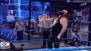 Man Standing in Wrestling Ring With Referee