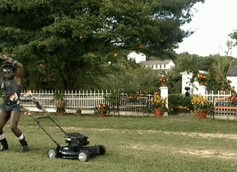 Man Standing Next To Black Lawn Mower GIF