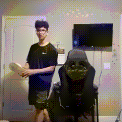 Man Standing Next to Chair With TV