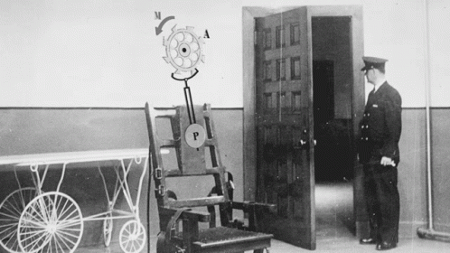 Man Standing Next to Electric Chair