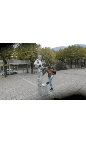 Man Standing Next to NY Hat Statue