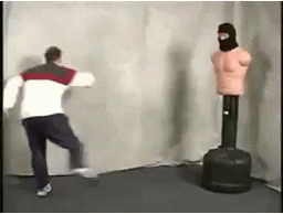 Man Standing Next to Punching Bag and Mannequin Wearing Mask
