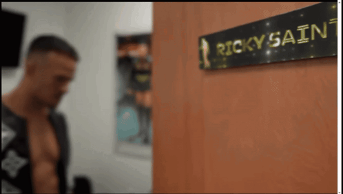 Man Standing Next To Ricky Sainz Sign GIF