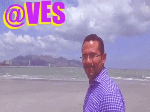 Man Standing on Beach With @ves