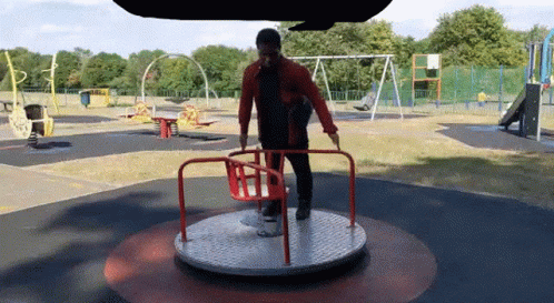 Man Standing on Merry Go Round in Park