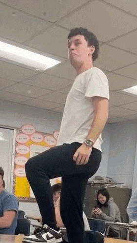 Man Standing on One Leg in Classroom