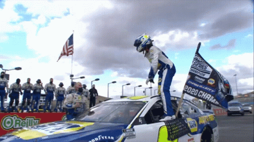 Man Standing on Race Car with 2020 Champion Flag