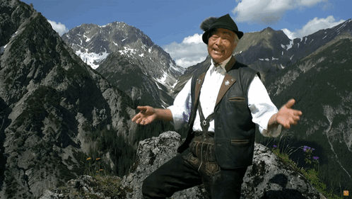 Man Standing on Rock in Mountain