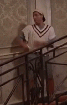 Man Standing on Stairs in Hat and White Sweater