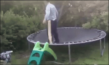 Man Standing On Trampoline Next To Green Slide GIF