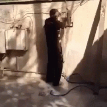 Man Standing With Hose Attached